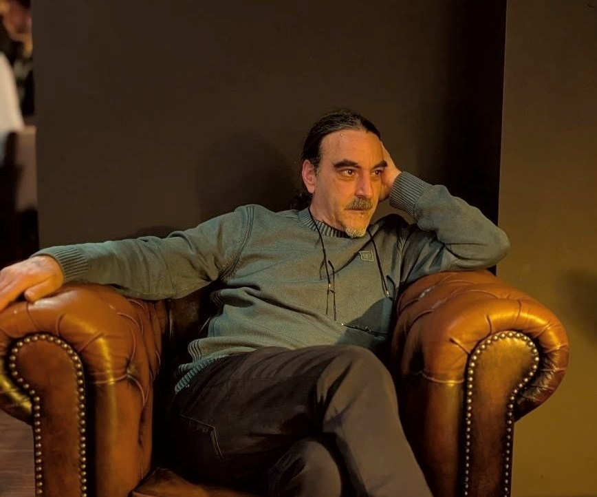 Warmes, redaktionelles Porträt von Dr. Tarek Krohn in seinem akustischen Bibliotheksstudio